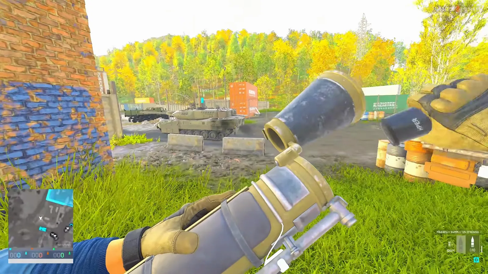 Gunner reloading the MAAWS with the smoking target tank visible downrange through a compound gate between rear hits