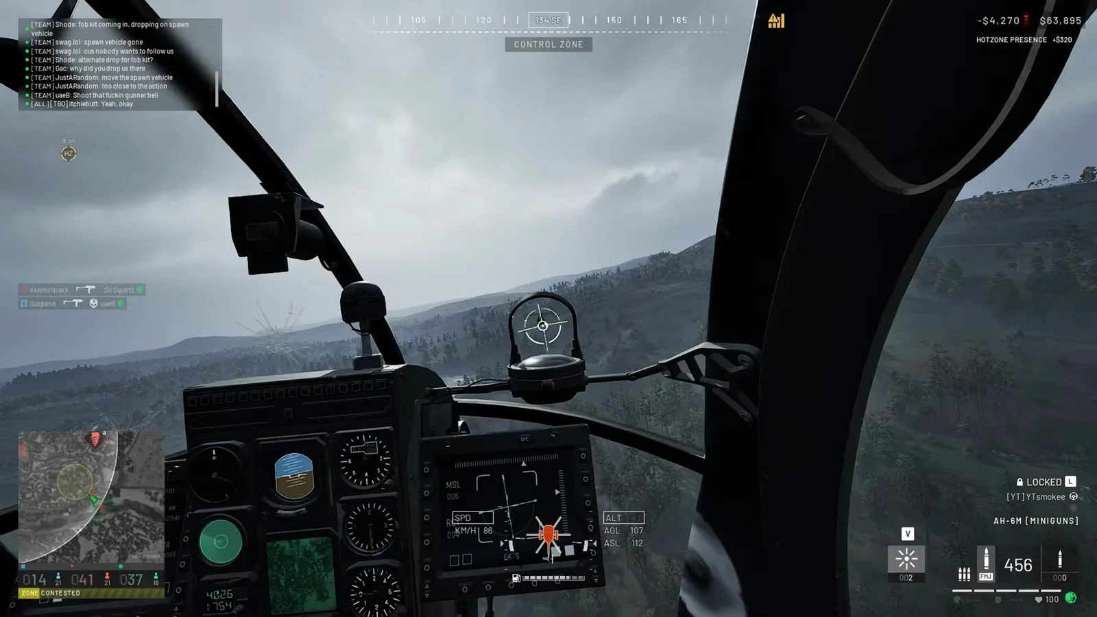 WARDOGS AH-6M [MINIGUNS] 座舱 HUD 显示 HOTZONE PRESENCE 加三百二十美元收益行，左侧座舱玻璃一片弹着蛛网裂纹，下方 ZONE CONTESTED 横幅